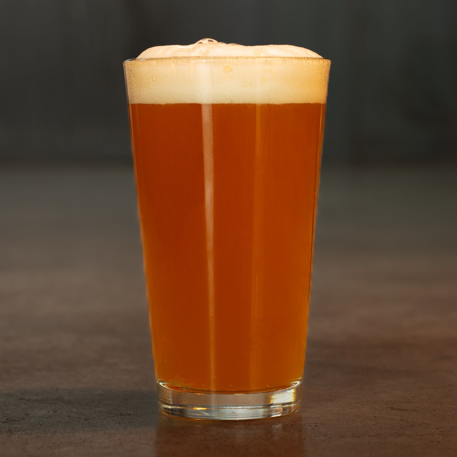 Pint of Manny's pale ale by Georgetown Brewing on the cement floor of the tasting room