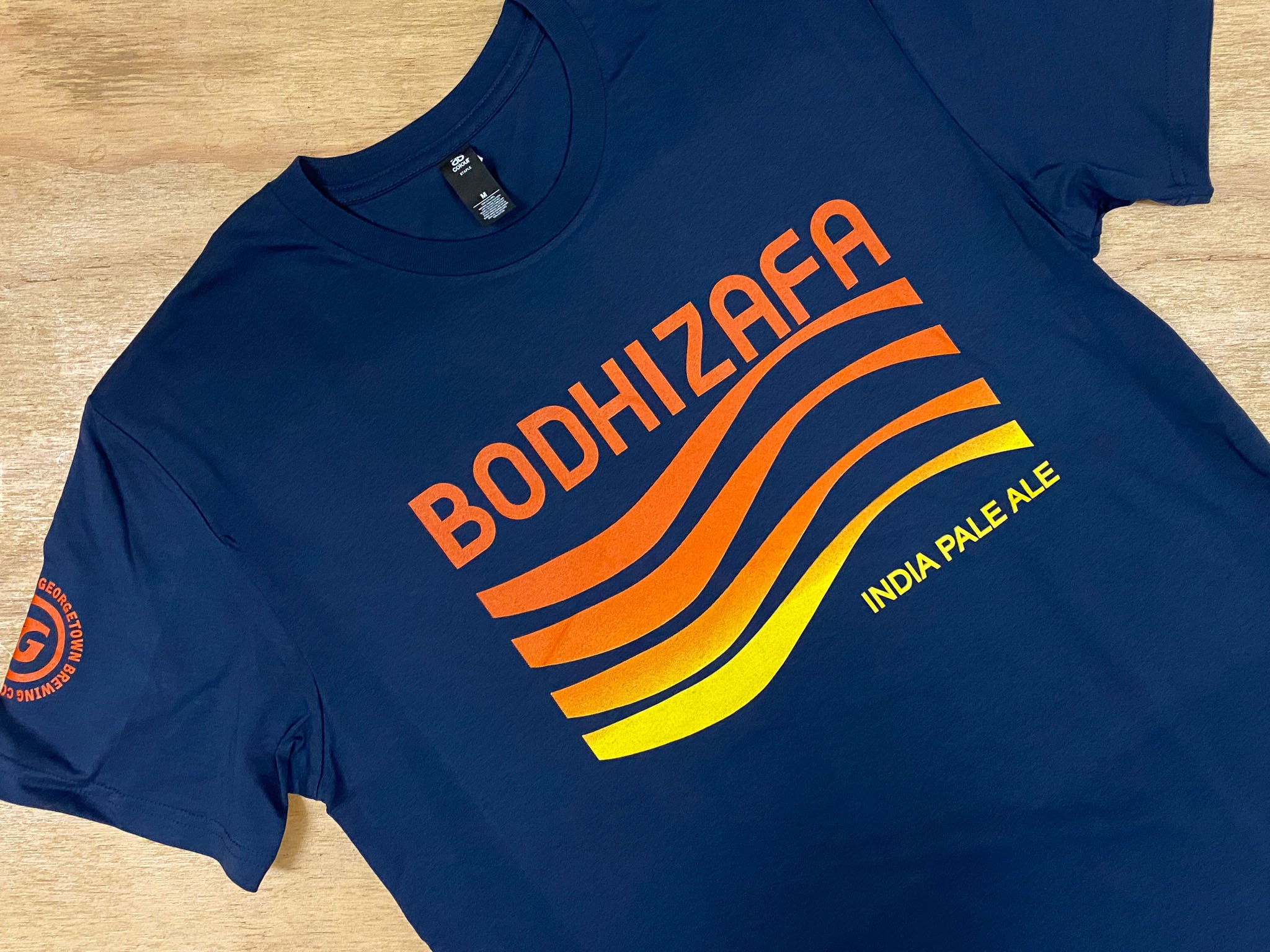 a navy shirt with words Bodhizafa India Pale Ale and a wave design in orange and yellow
