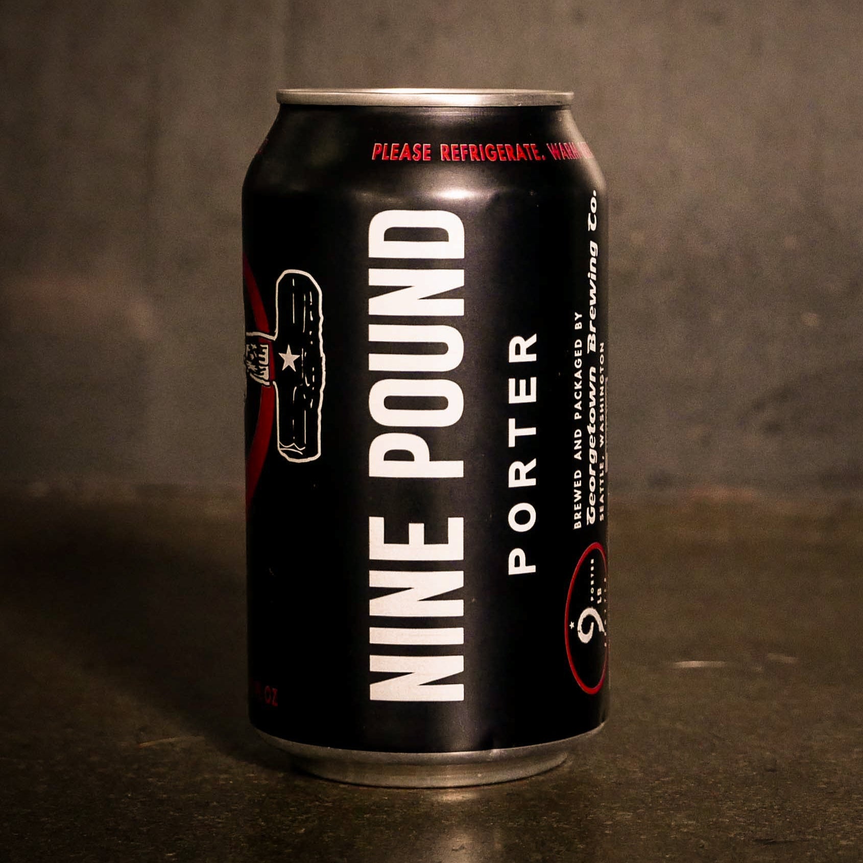 Can of 9lb porter beer by Georgetown Brewing on the cement floor of the tasting room