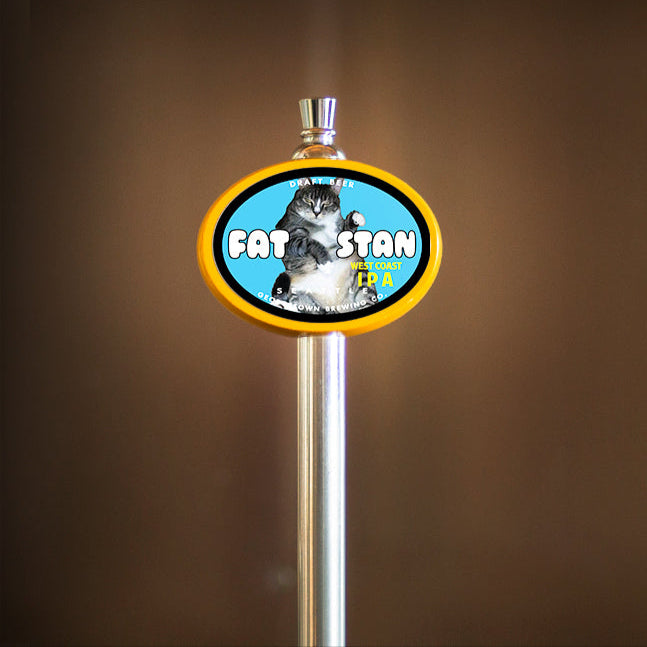 Brewery tap handle with 'Fat Stan' branding on a blurred background