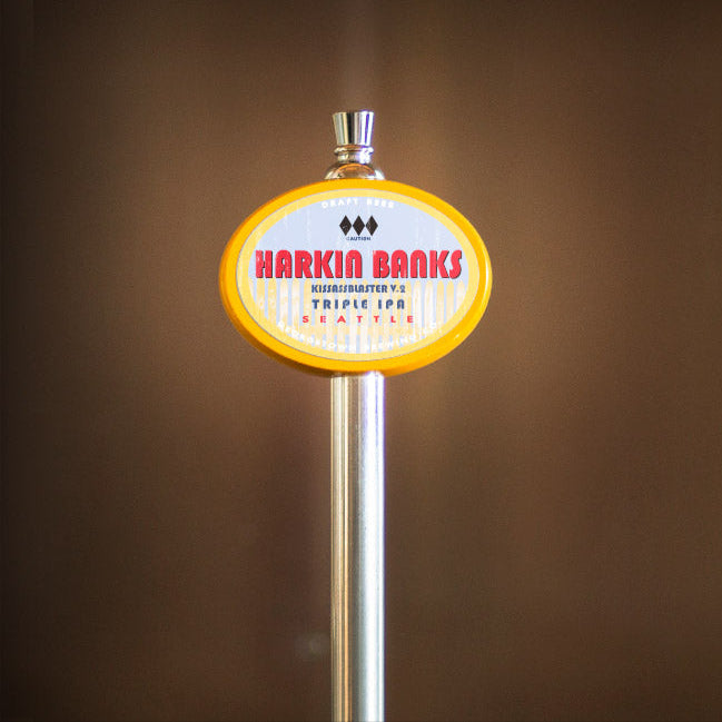 Beer tap handle with 'Harkin Banks' label on a blurred background