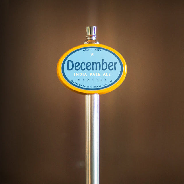Beer tap handle with 'December' branding against a brown background