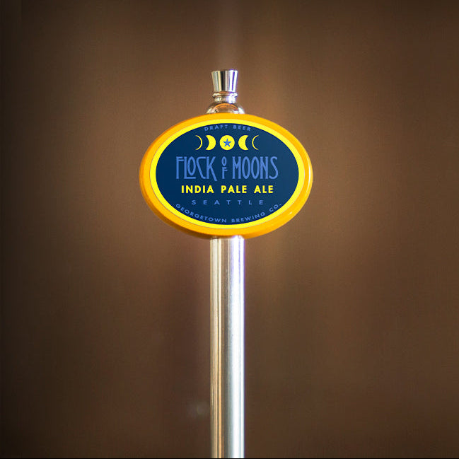Beer tap with 'Flock of Moons India Pale Ale' label against a brown background