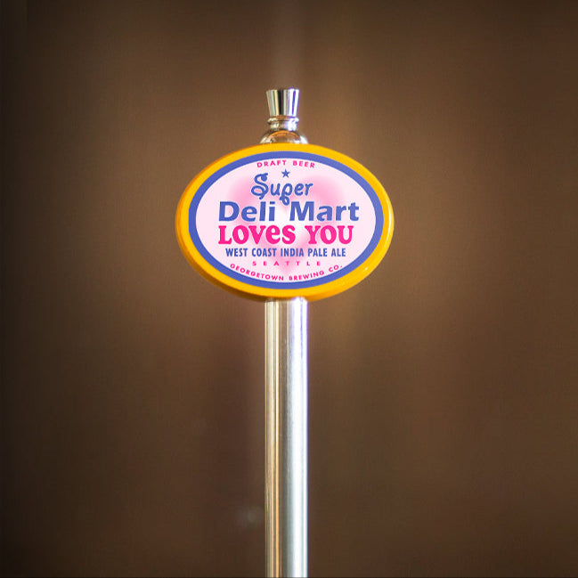 beer handle with a colorful sign reading 'Super Deli Mart LOVES YOU' against a brown background
