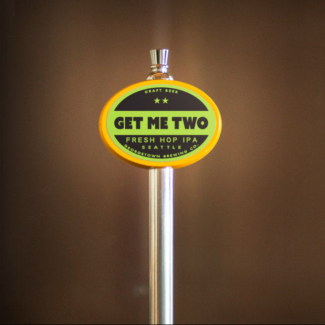 Beer tap handle with 'Get Me Two' label on a brown background