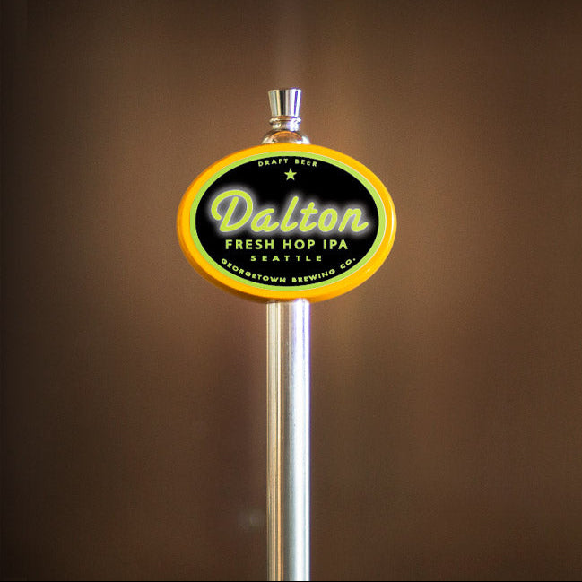 yellow oval beer tap with Dalton Fresh Hop IPA label on a brown background