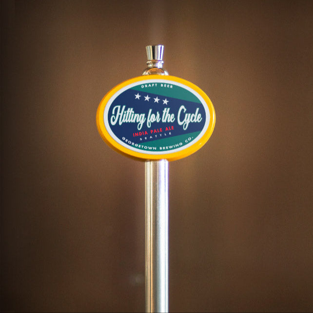 beer tap handle with a circular logo for hitting for the cycle ipa on a brown background
