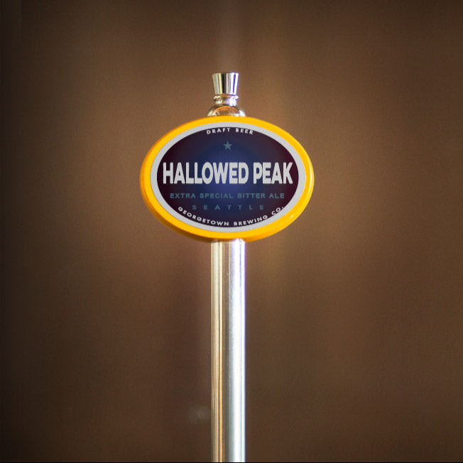 Hallowed Peak beer tap handle against a brown background