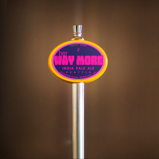 Tap handle with 'her way more' label on a blurred background