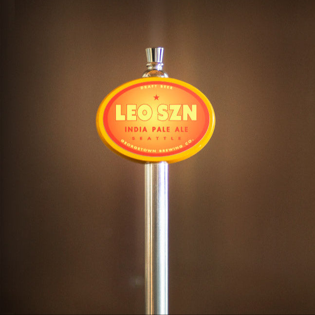 Leo szn India Pale Ale tap handle against a brown background
