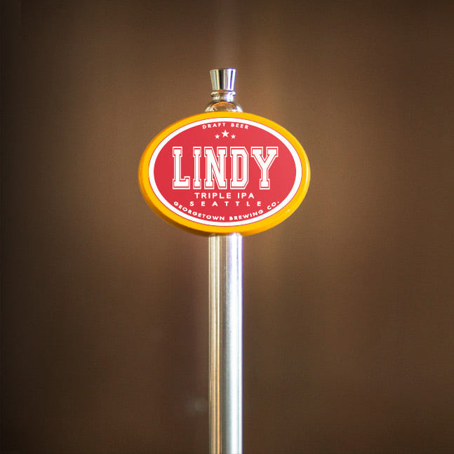 Lindy's Triple IPA beer tap handle on a brown background