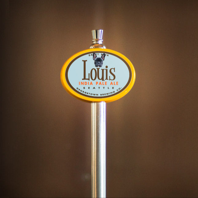 Beer tap handle with 'Louis' label against a blurred background