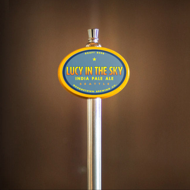 Beer tap handle with 'Lucy in the Sky' label against a brown background