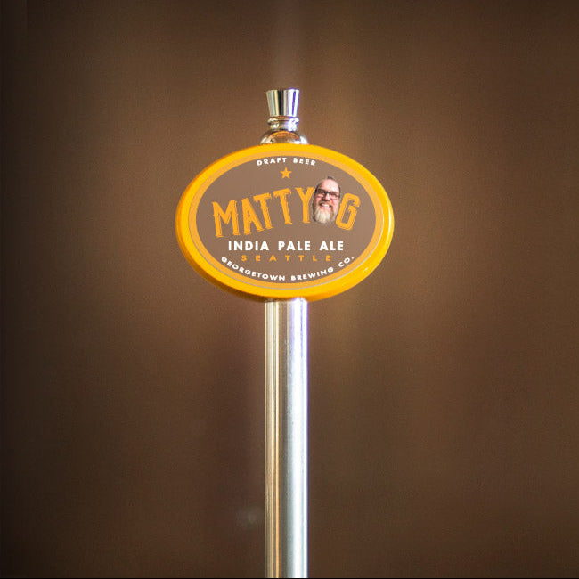 Matty G India Pale Ale tap handle against a brown background