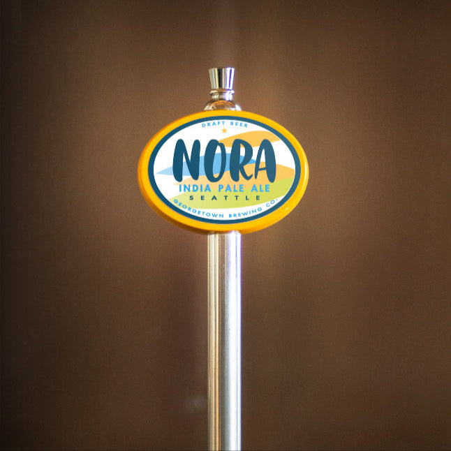 Nora India Pale Ale tap handle against a brown background