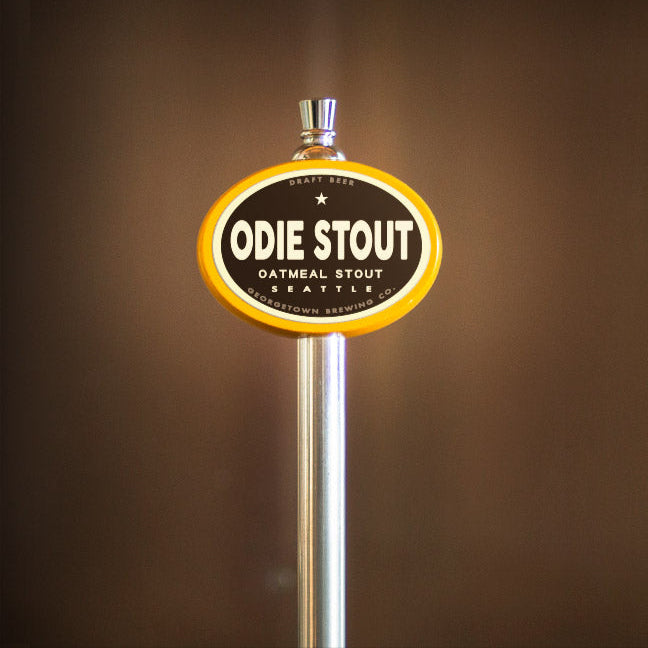 Beer tap handle with 'Odie Stout' label on a brown background