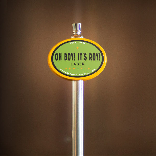 Beer tap handle with 'Oh Boy! It's Boy!' Lager label on a brown background