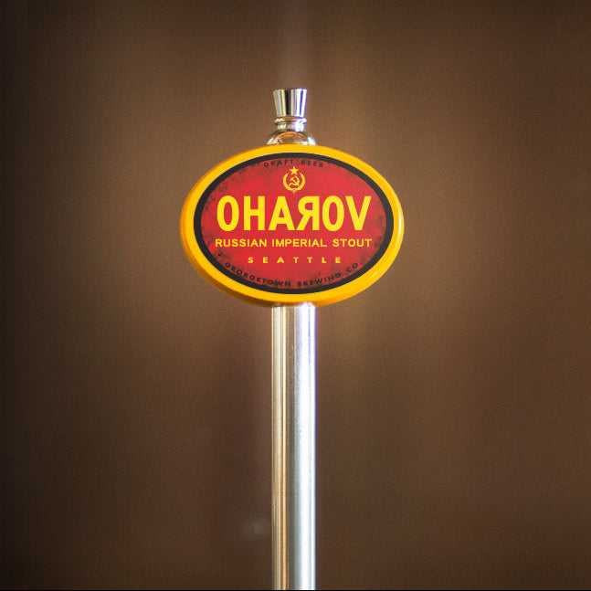 Beer tap handle with 'Oharov' branding on a blurred background
