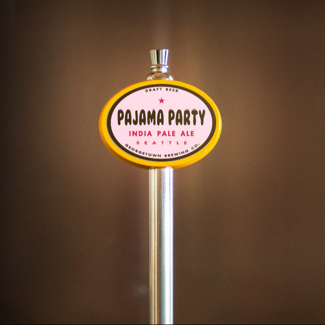 Pajama Party India Pale Ale tap handle against a brown background