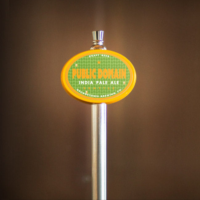 Tap handle with 'Public Domain India Pale Ale' label on a blurred background