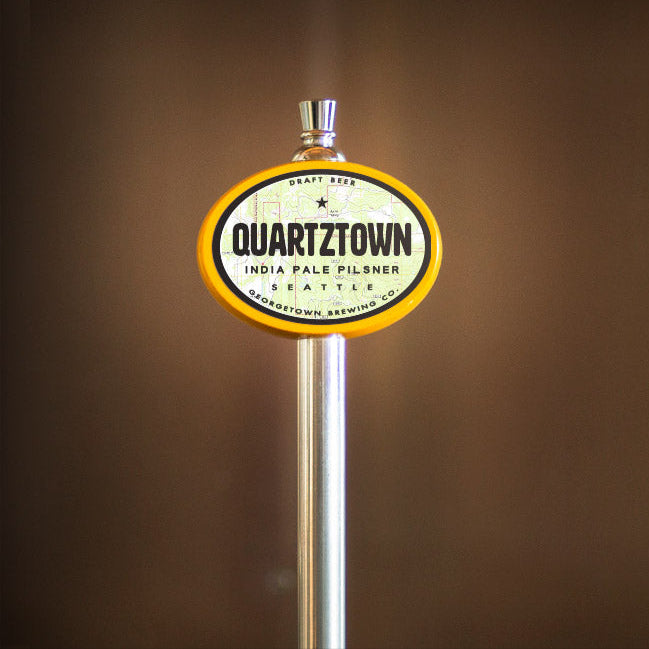 Quartztown beer tap handle against a brown background