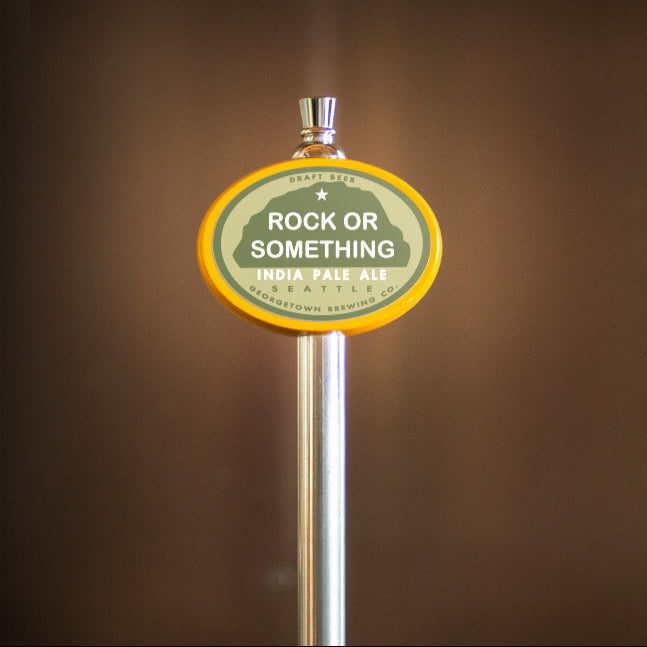 Beer tap handle with 'Rock or Something' label against a brown background