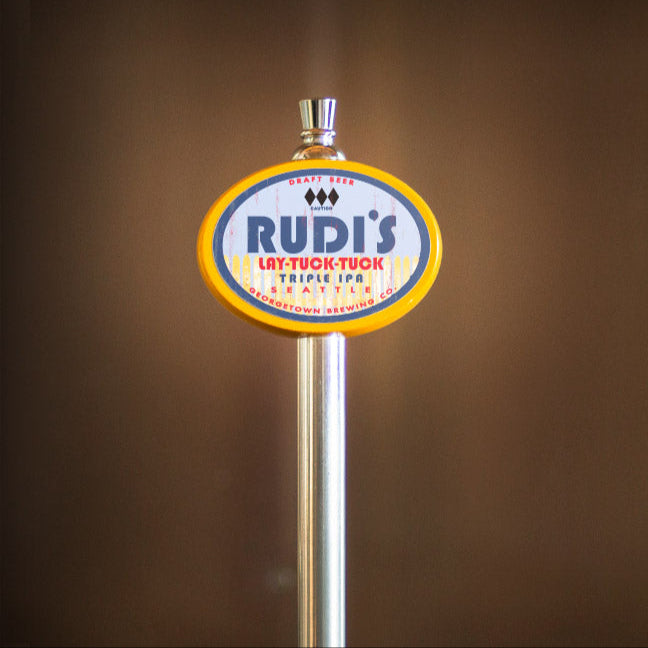 Rudi's beer tap handle against a brown background