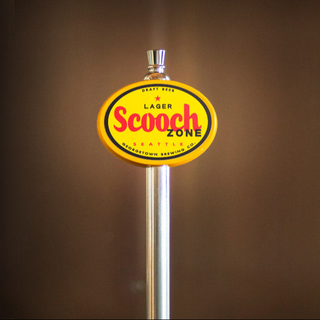 yellow beer tap handle with 'Scooch Zone' label on a brown background