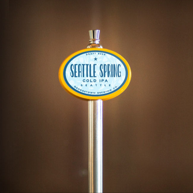 Beer tap with 'Seattle Spring' label against a brown background