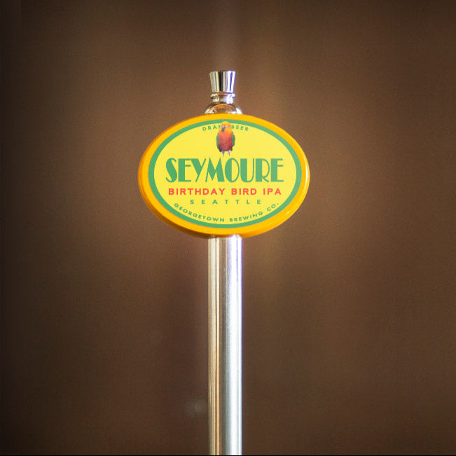 Seymour Birthday Bird IPA beer tap handle against a brown background