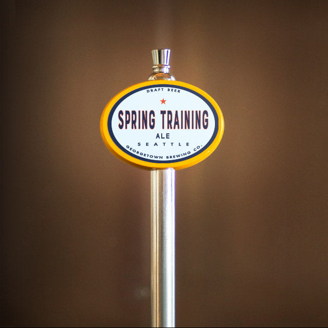 Beer tap handle with 'Spring Training Ale' label against a brown background