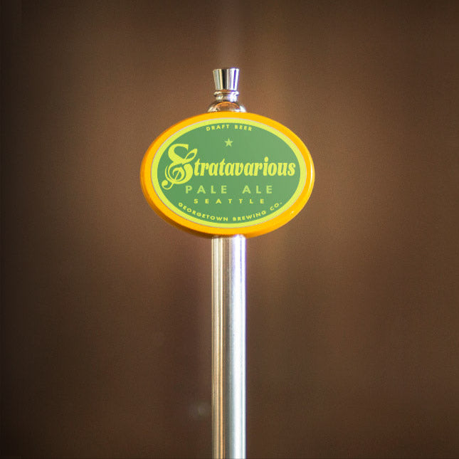 Stratarvarious Pale Ale tap handle on a blurred brown background