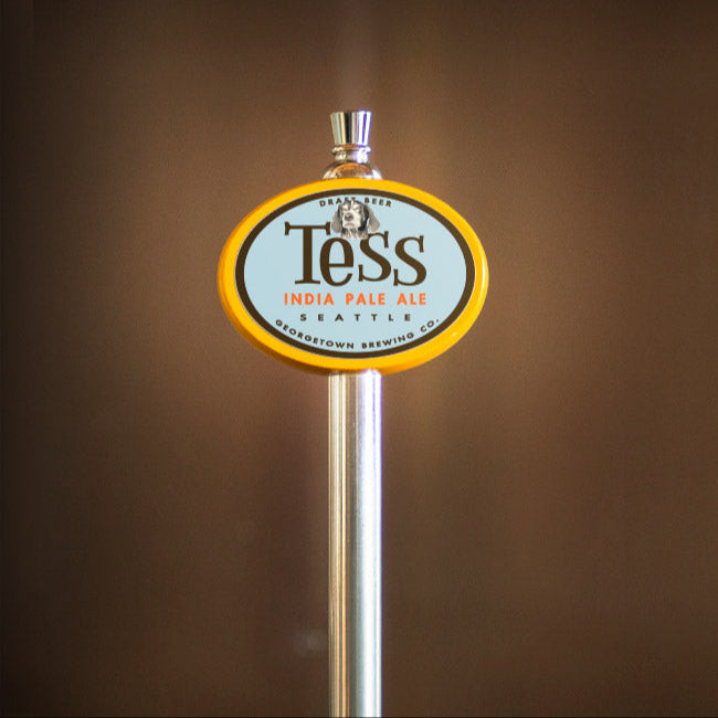 Tess India Pale Ale beer tap handle against a brown background
