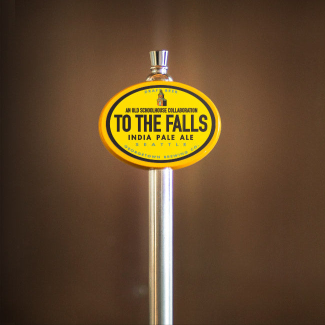Beer tap handle with 'To The Falls' India Pale Ale label on a brown background