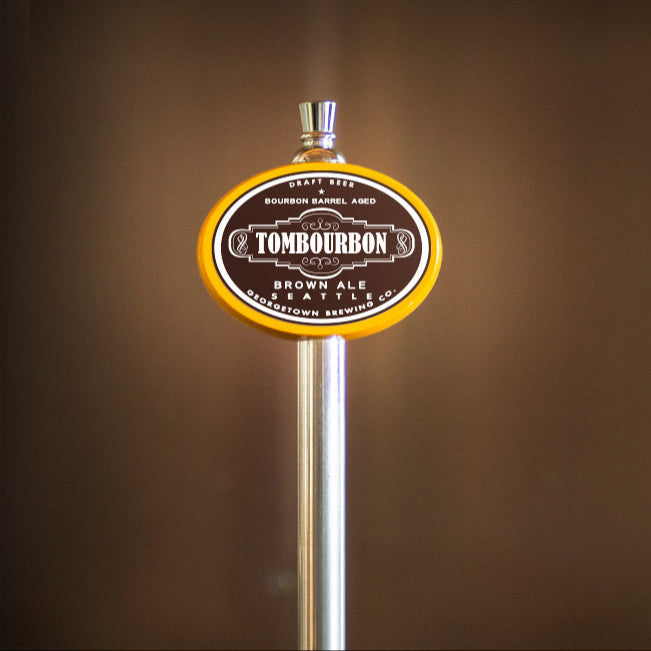 Tombourbon Brown Ale tap handle against a brown background