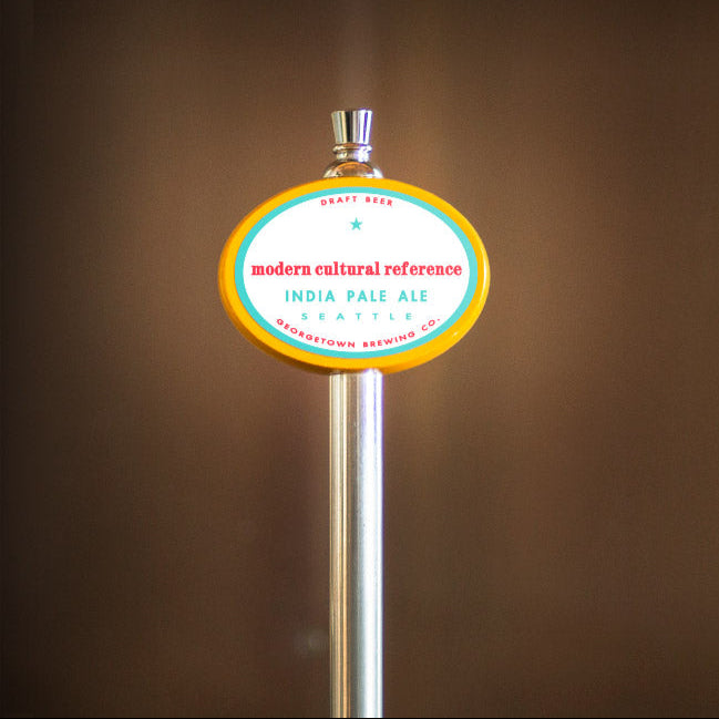 Beer tap handle with Modern Cultural Reference IPA label against a brown background