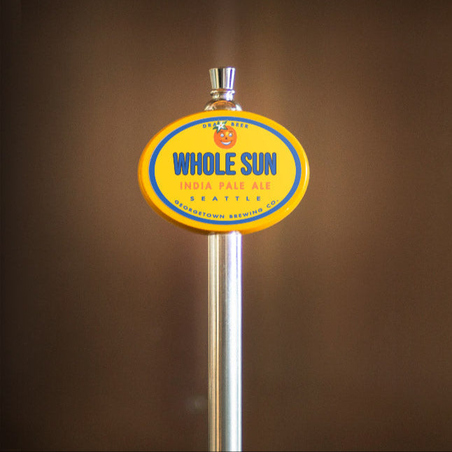 Beer tap handle with 'Whole Sun' label against a brown background