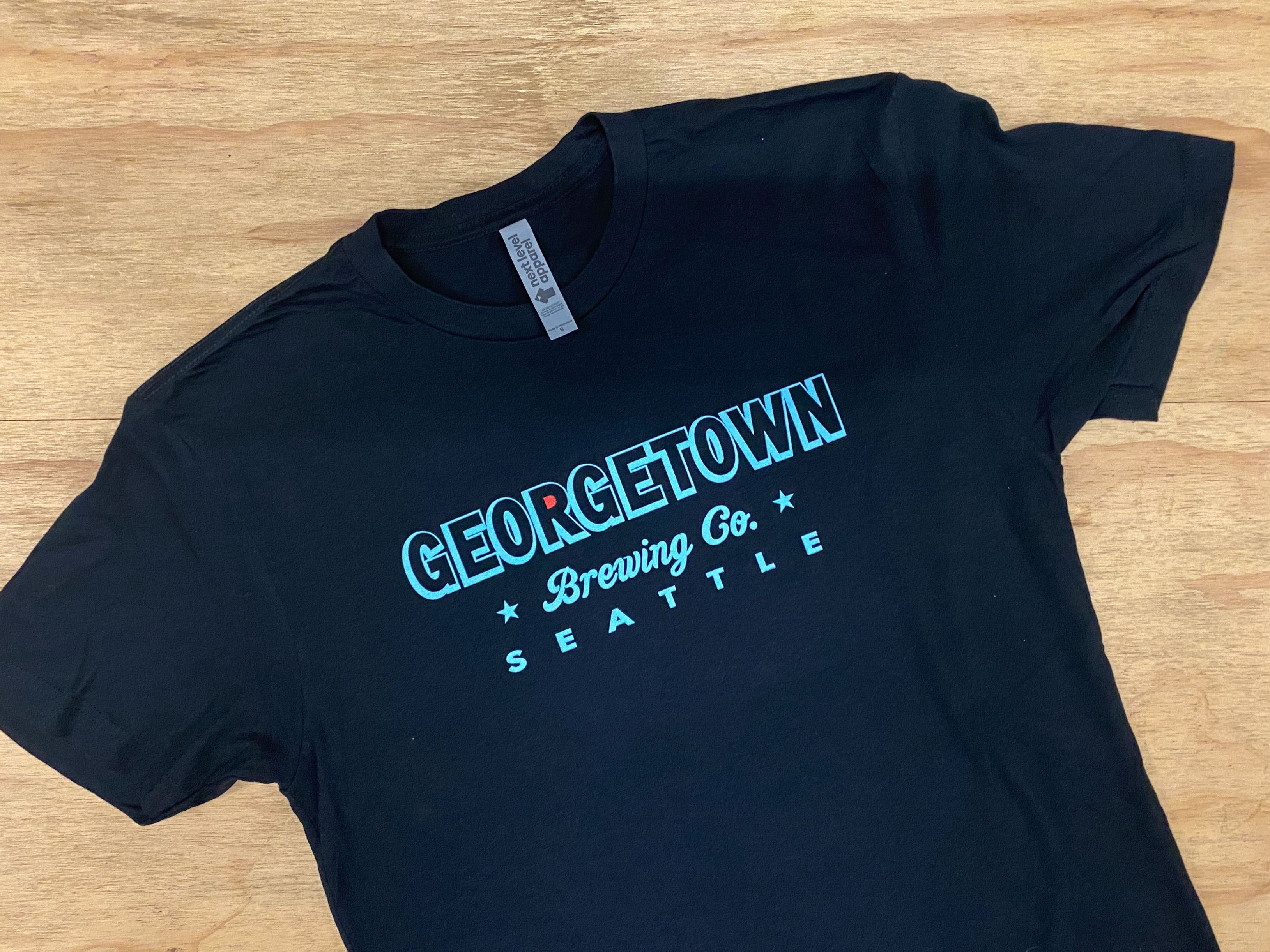 Black t-shirt with 'Georgetown Brewing Co. Seattle' text in Kraken colors. The center of the R in Georgetown is colored in red like the kraken logo