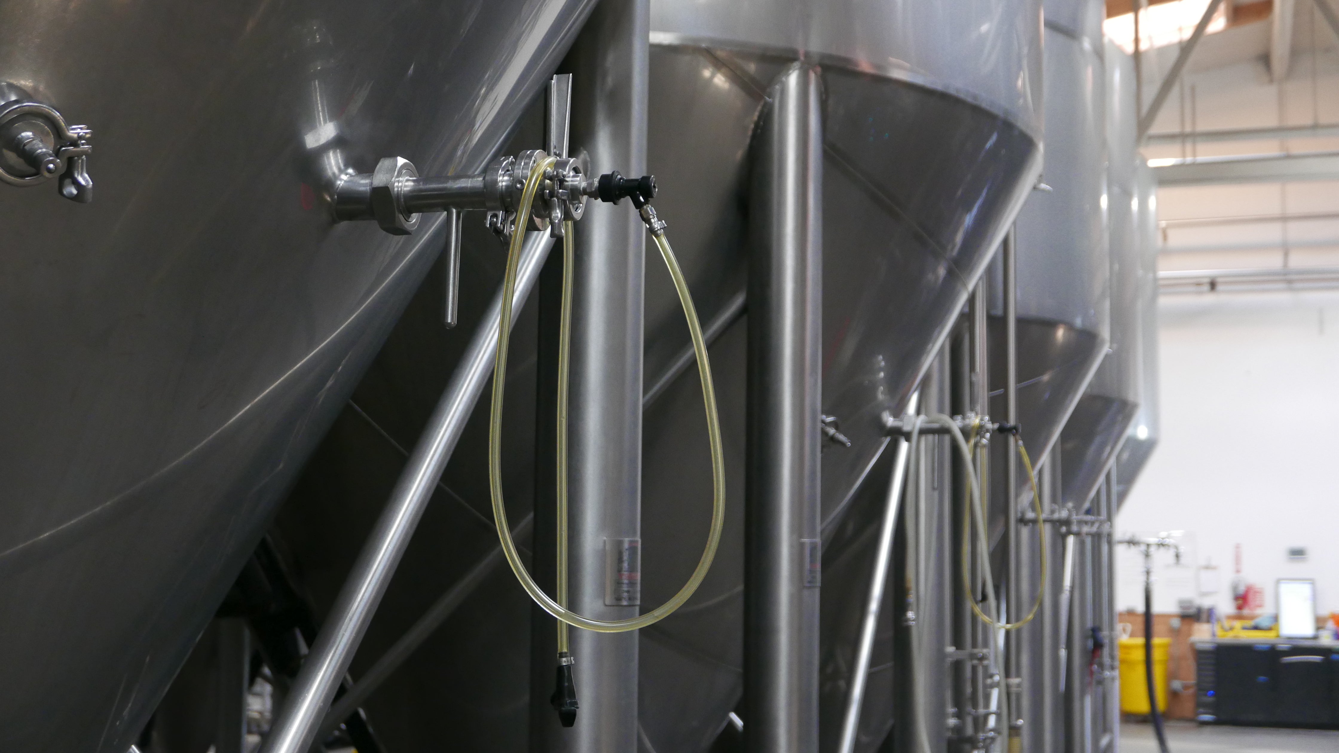 A thin plastic hose with a dispenser is hanging off one of the bright tanks