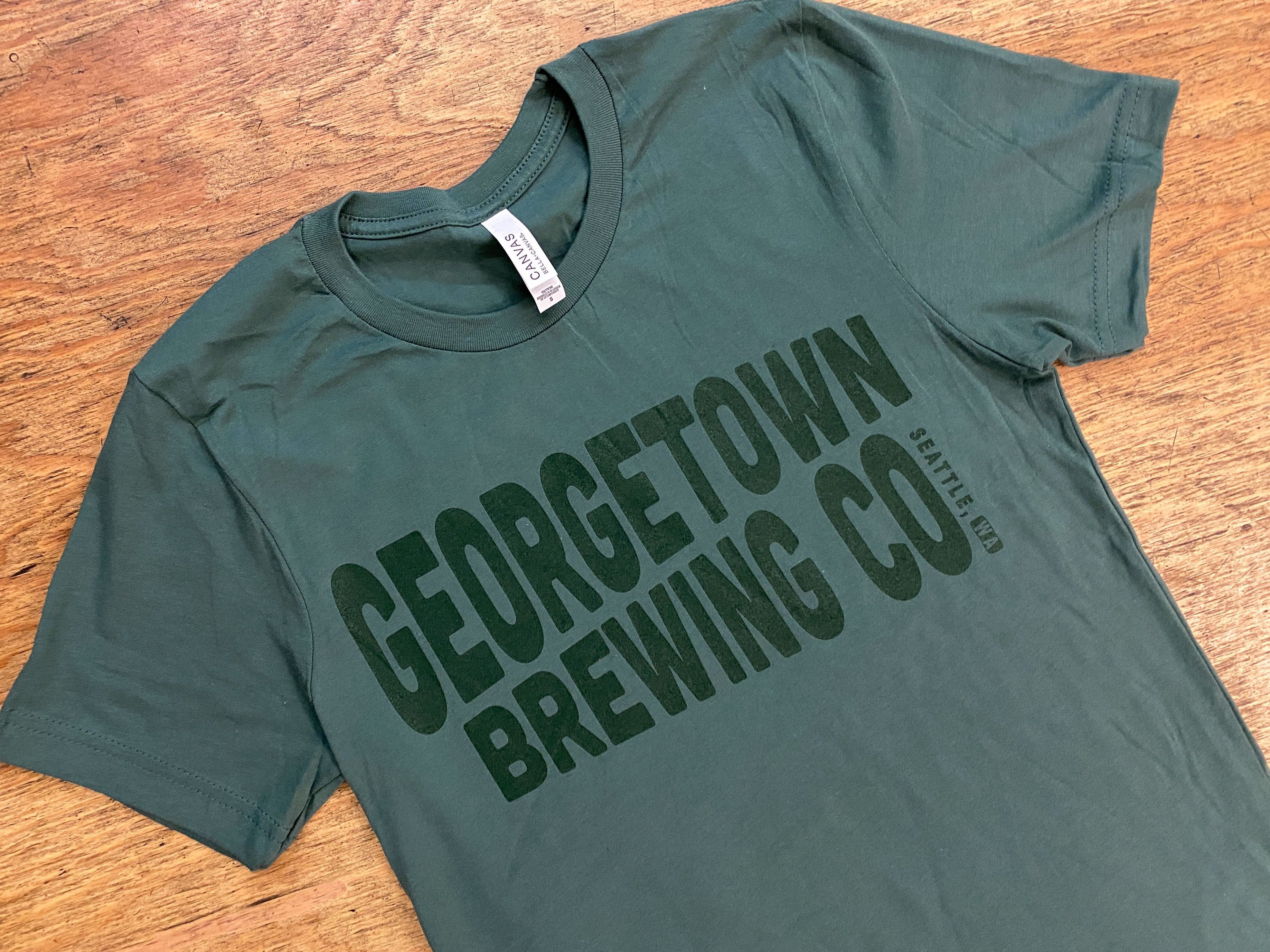Pine green shirt with Georgetown logo also in a green ink print. 