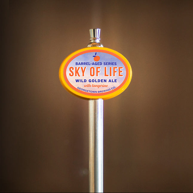 Beer tap handle with 'Sky of Life' label against a brown background