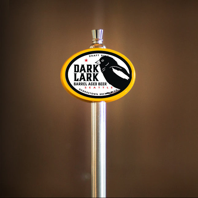 Dark Lark tap handle featuring a Lark Bunting, a small black seed eating bird with a white patch on its wing. 