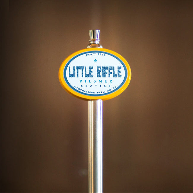 Beer tap handle with 'Little Riffle' label against a brown background