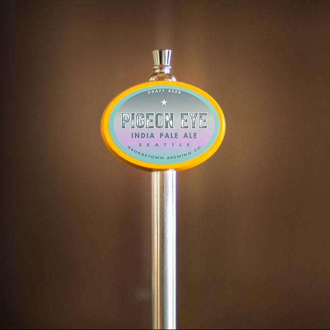 Pigeon Eye beer tap handle with a label on a brown background