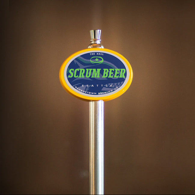 Beer tap with 'Scrum Beer' label against a brown background