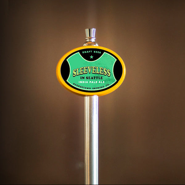 A close-up of a beer tap handle with an oval sign reading 'Sleeveless in Seattle' set against a dark brown blurred background.