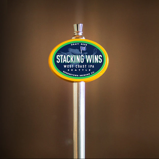 Beer tap handle with 'Stacking Wins' label against a brown background