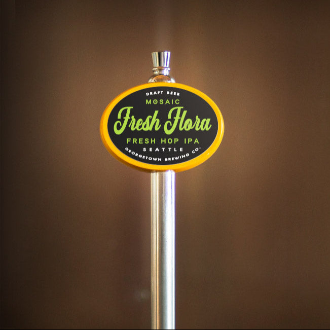 Beer tap handle with 'Fresh Flora' branding on a brown background