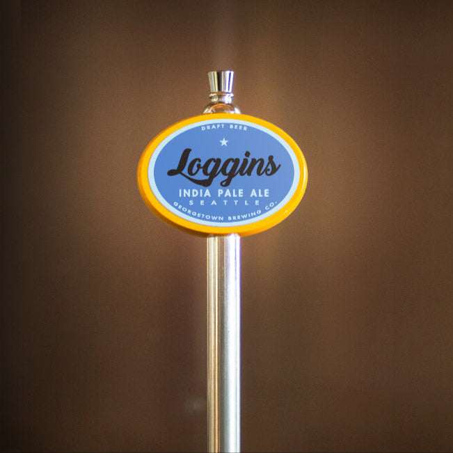 Beer tap handle with 'Loggins' label against a blurred background