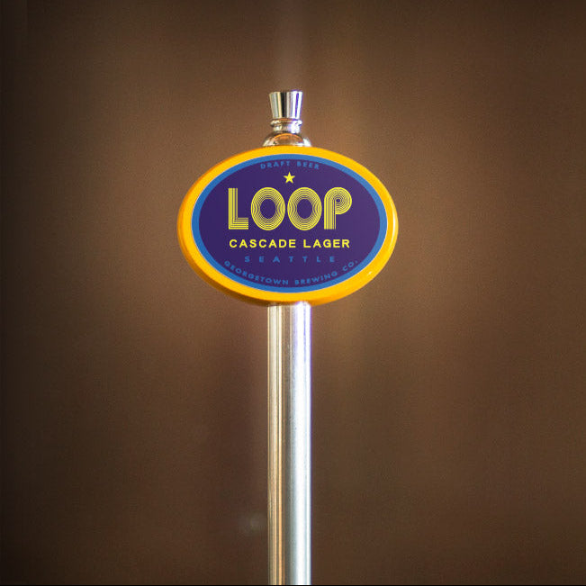 Loop Cascade Lager beer tap handle on a brown background